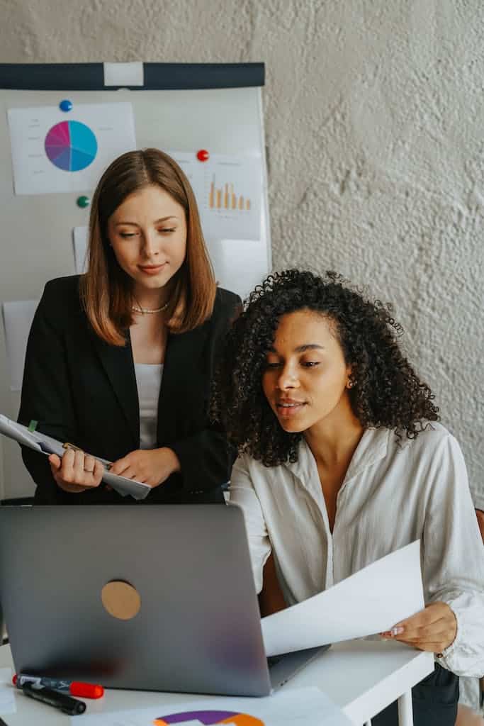 How Often Should I Update The Company Website? 1 Two Women Holding Papers while Looking at Laptop Screen